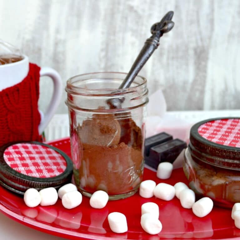 DIY hot cocoa mix in a glass mason jar with marshmallows on the side.