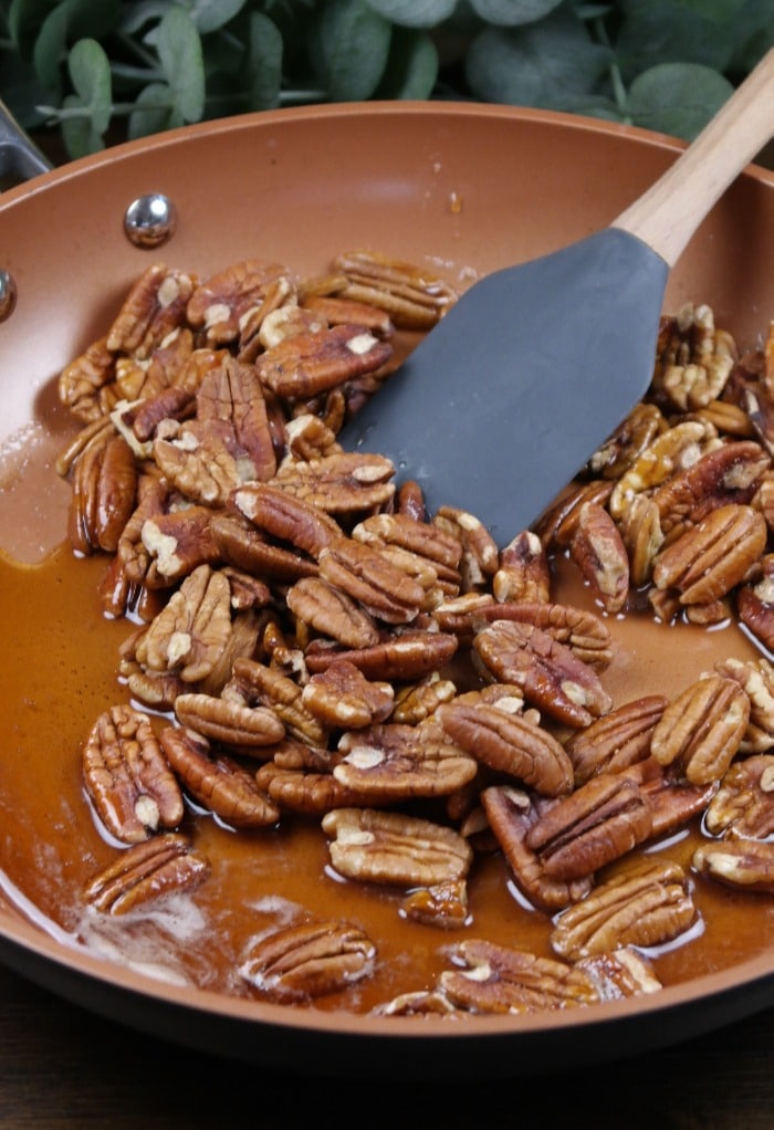 Warm skillet with maple syrup and pecans. 