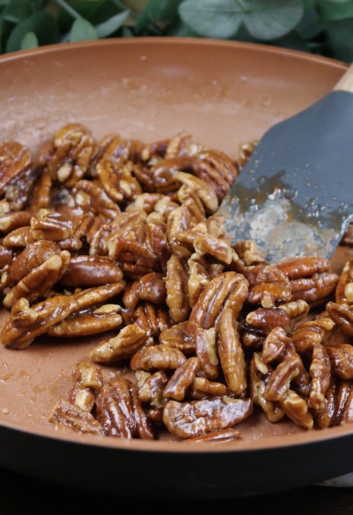 Caramelized pecans in a skillet pan.  