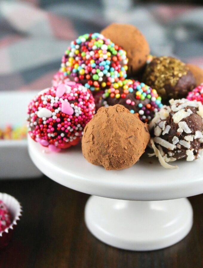 A mini white cupcake stand filled with chocolate truffles