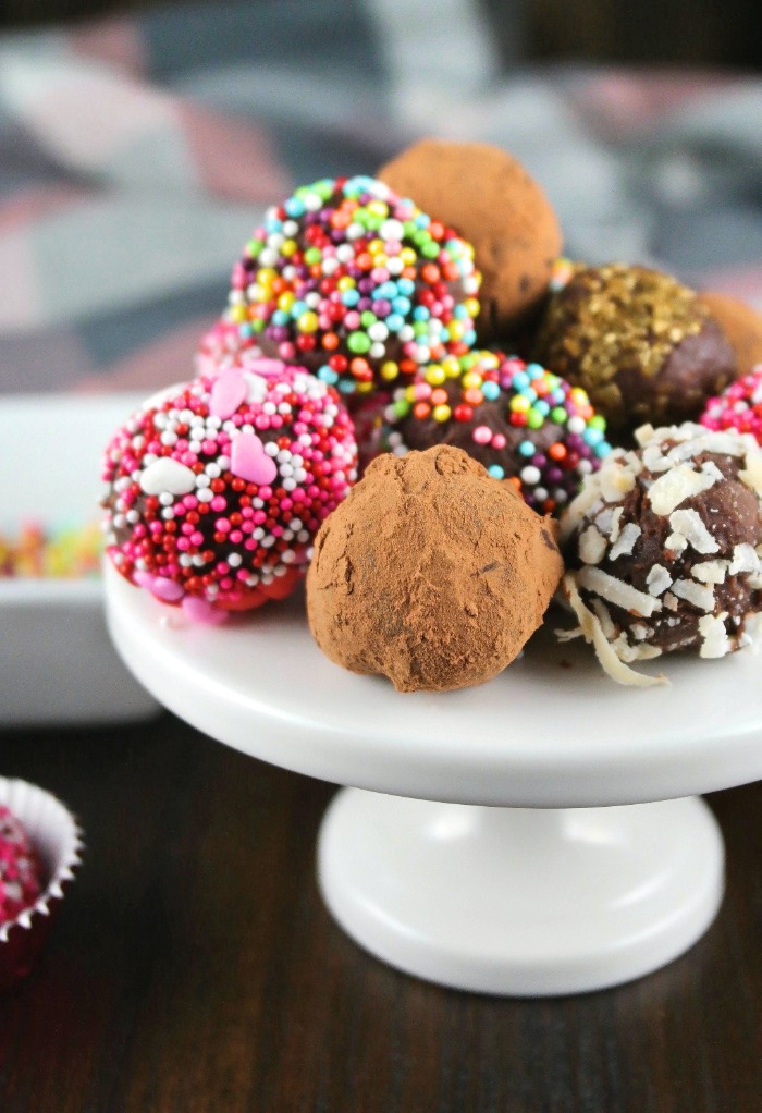 A mini white cupcake stand filled with chocolate truffles