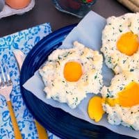 Light and fluffy whipped egg whites with the yolk in the center on a blue platter