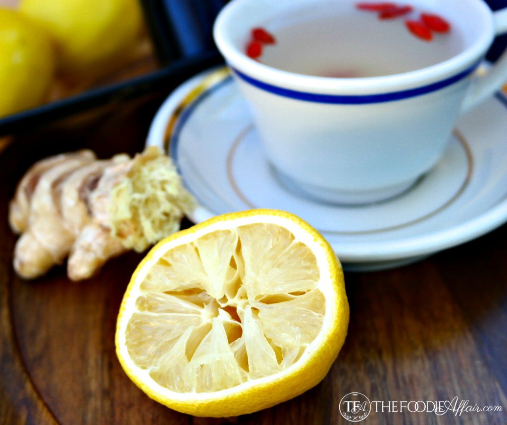 a teacup of lemon ginger detox tea with fresh squeezed lemon