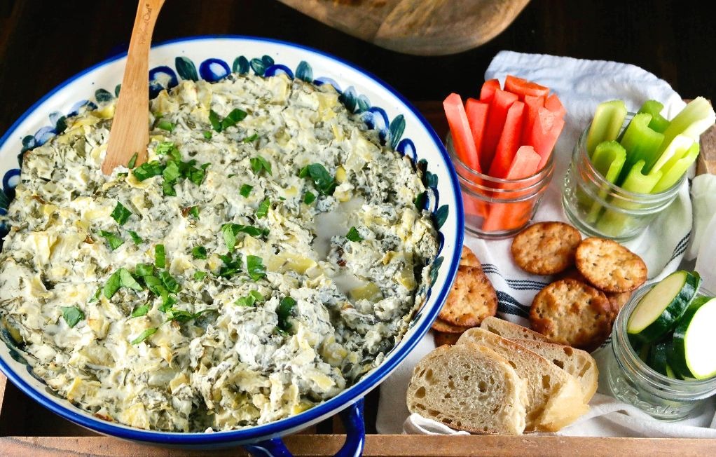 Horizontal shot of spinach dip with vegetables and crackers for dipping