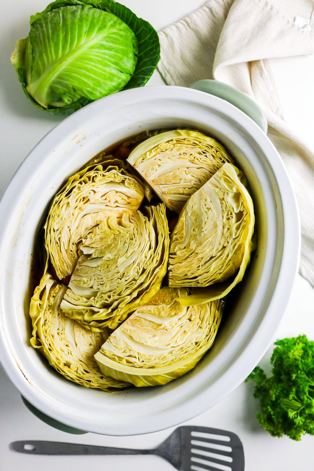 Sliced cabbage wedges in a slow cooker.