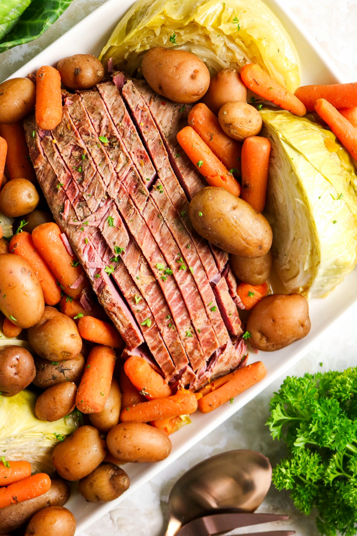 Sliced corned beef on a white platter.