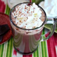 Irish Cream Hot Cocoa in a tall clear mug topped with whipped cream