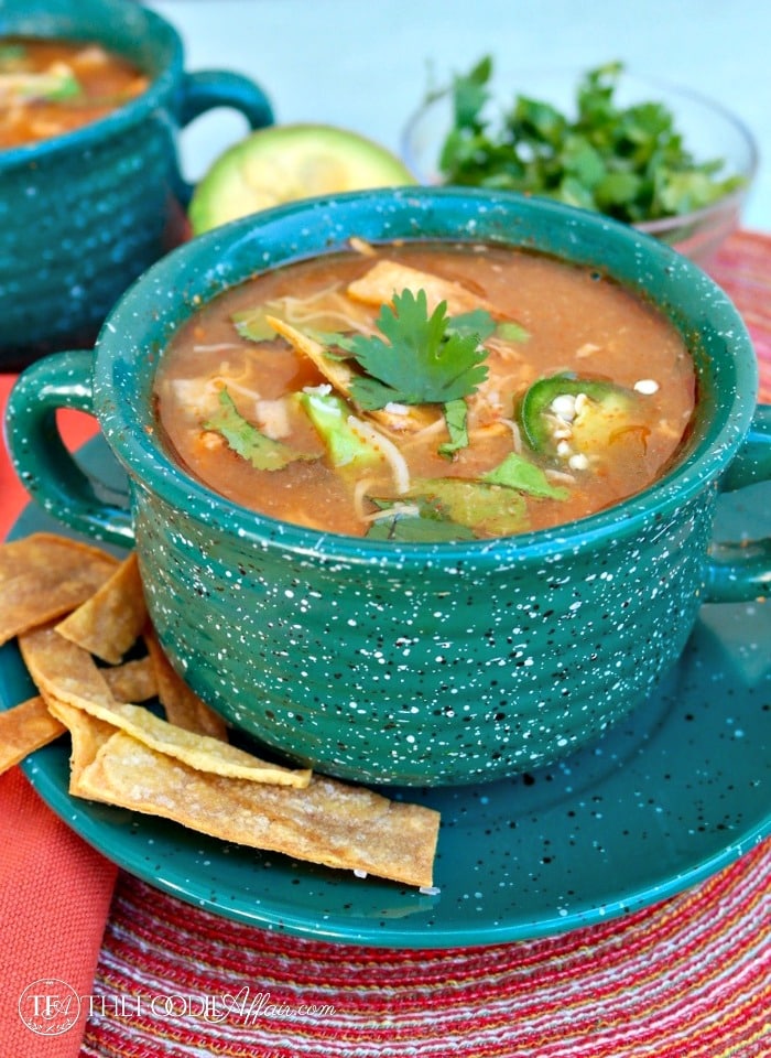 Slow cooker chicken tortilla soup in a green soup bowl 