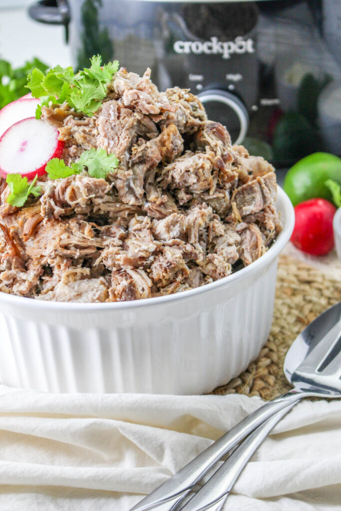 Pork carnitas shredded in a white serving bowl. 