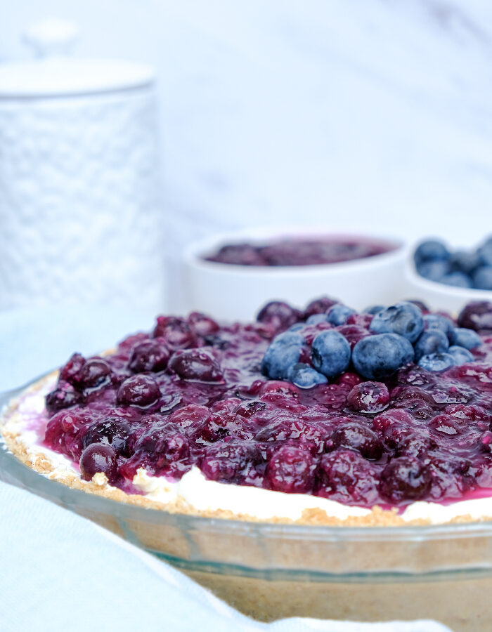 Homemade no bake blueberry cream cheese pie in a clear baking dish.