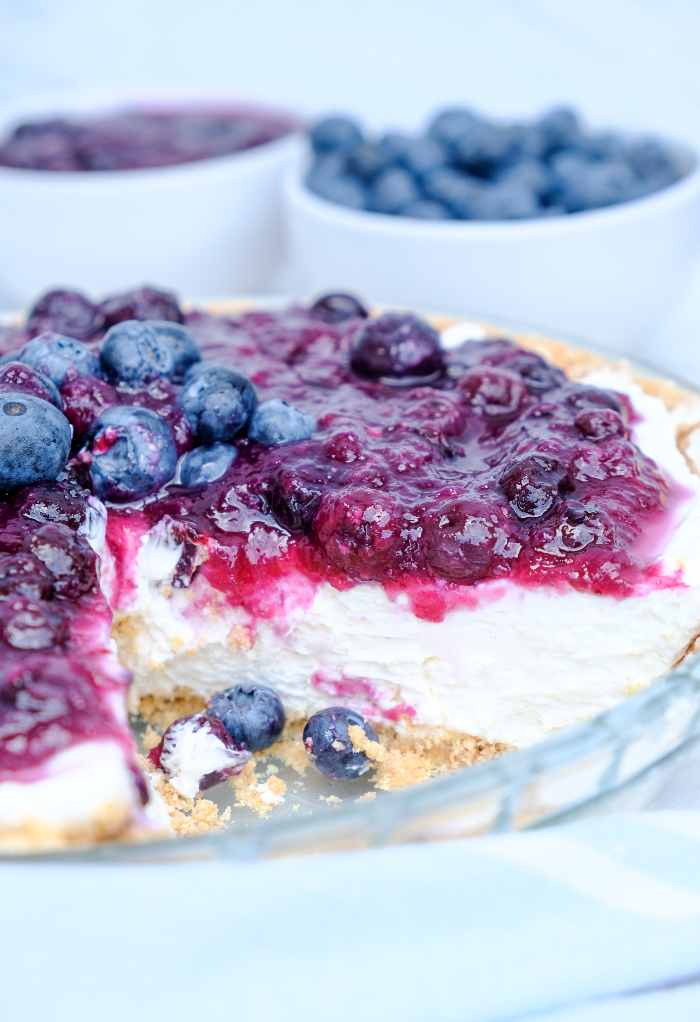A slice removed from a no bake blueberry cream cheese pie. 
