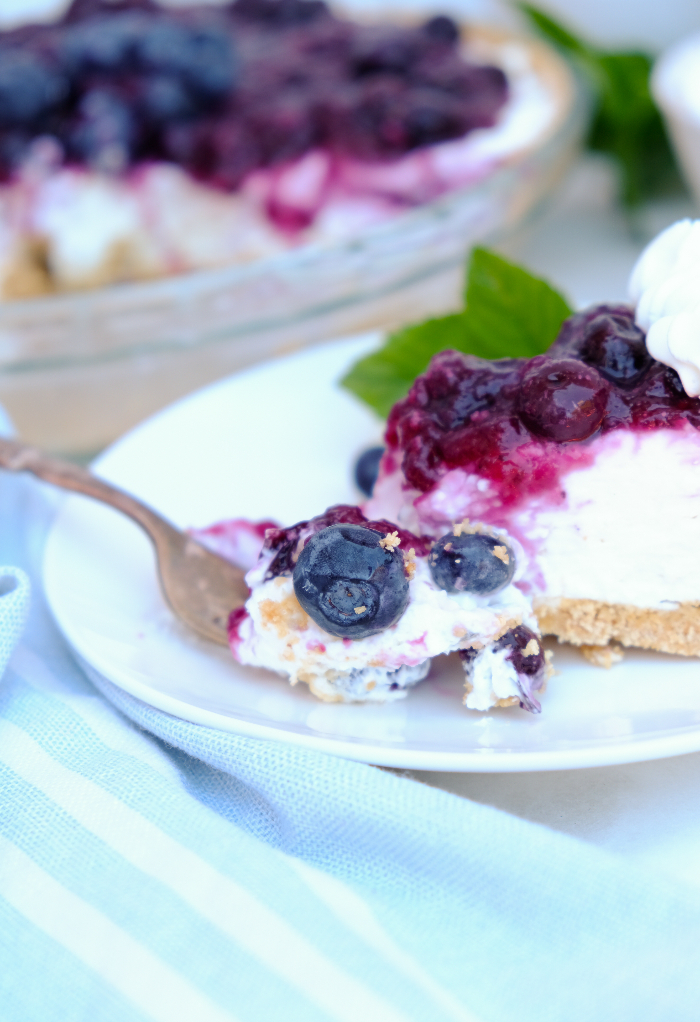 A slice of pie on a white plate ready to eat on a fork