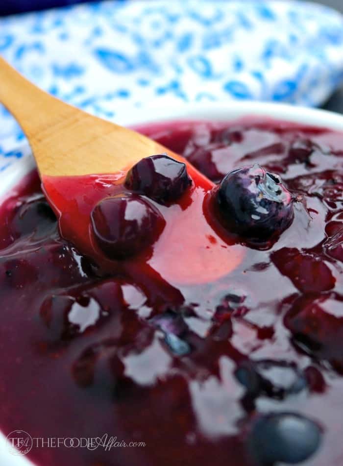 A wooden spoon dishing homemade blueberry sauce