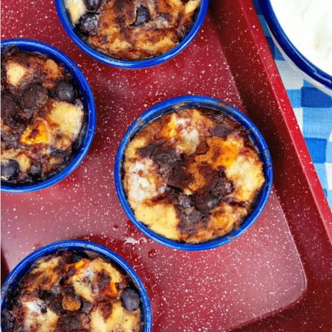 Mango Blueberry Bread Pudding in blue bowls on a red tray
