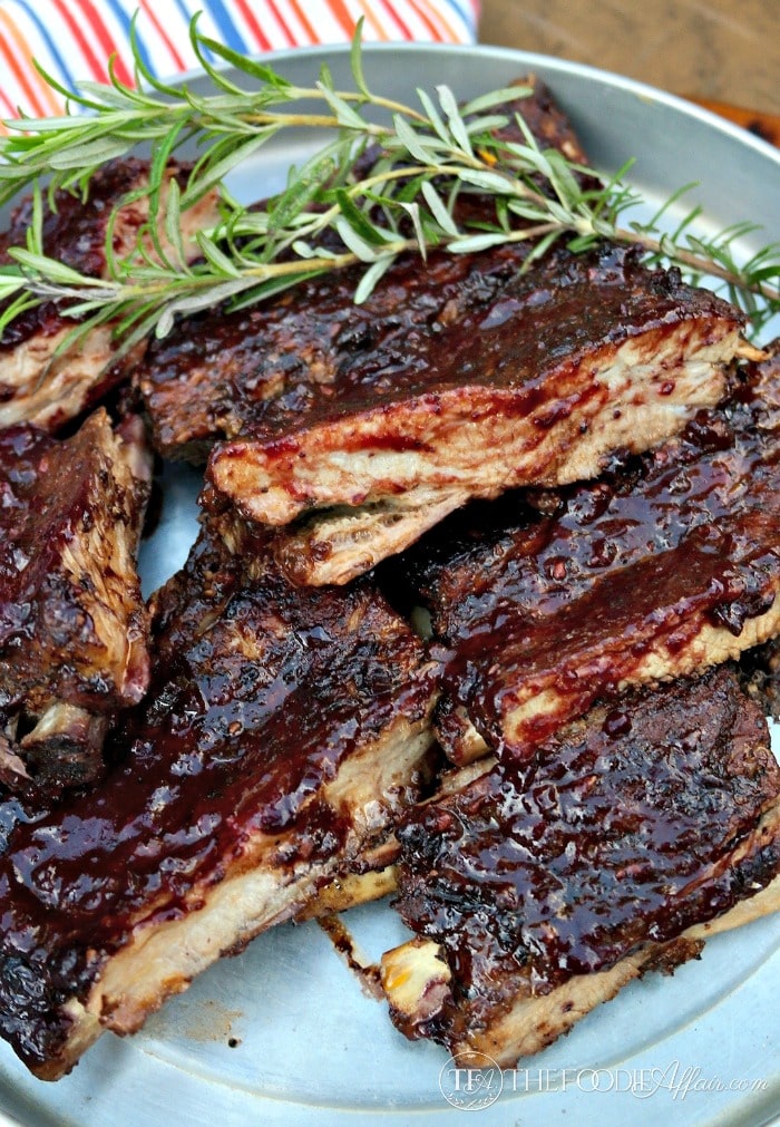 Baked ribs with blueberry bourbon sauce on a tin platter