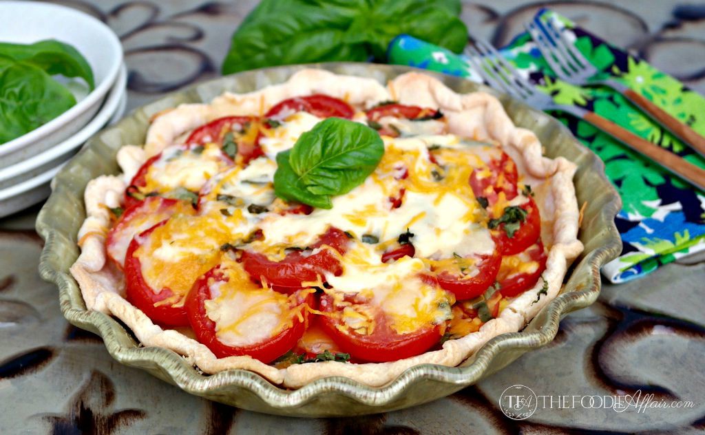 Fresh savory tomato pie topped with cheese, garlic and basil - The Foodie Affair