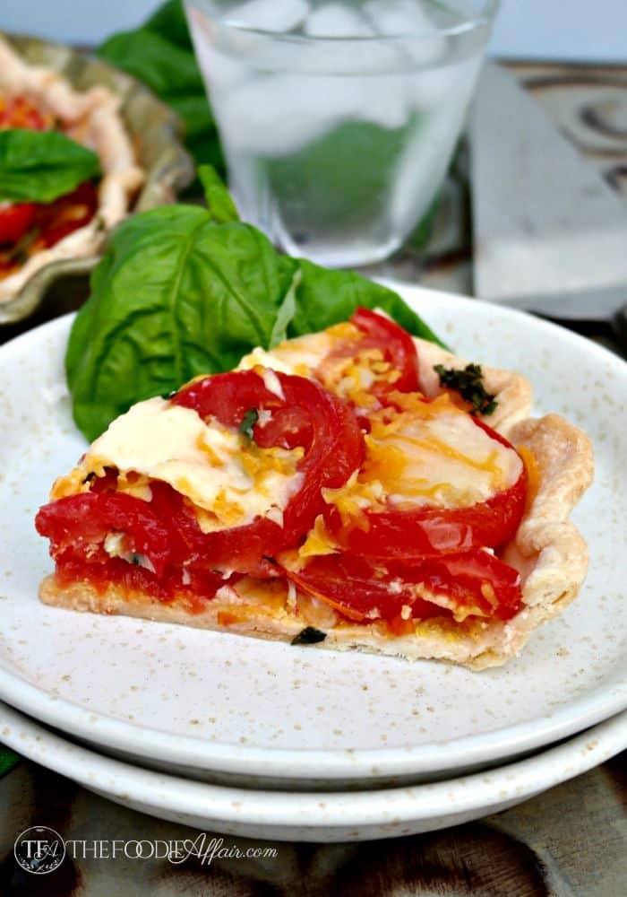 Fresh savory tomato pie topped with cheese, garlic and basil - The Foodie Affair