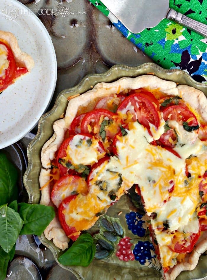 Fresh savory tomato pie topped with cheese, garlic and basil - The Foodie Affair
