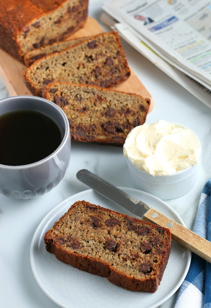 This image shows the finished easy banana bread with chocolate chips recipe served with coffee and butter. 