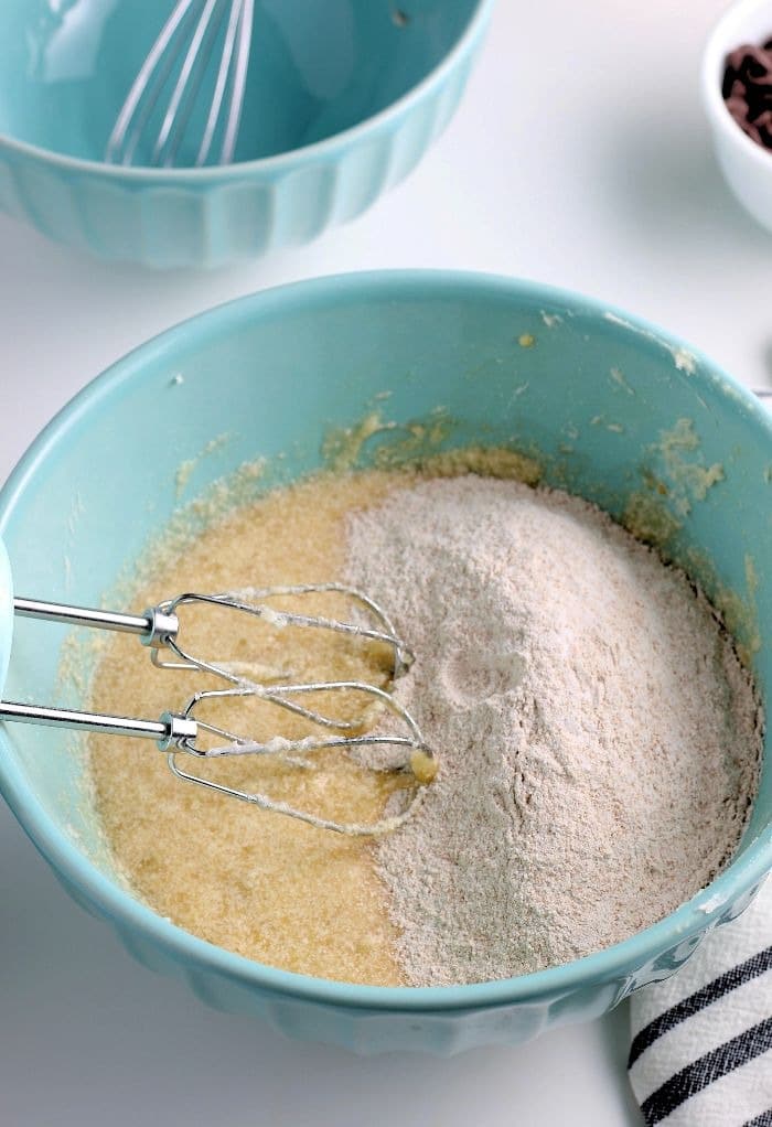 This photo shows the dry ingredients poured on top of the wet so they can be mixed together for banana bread with chocolate chip recipe. 