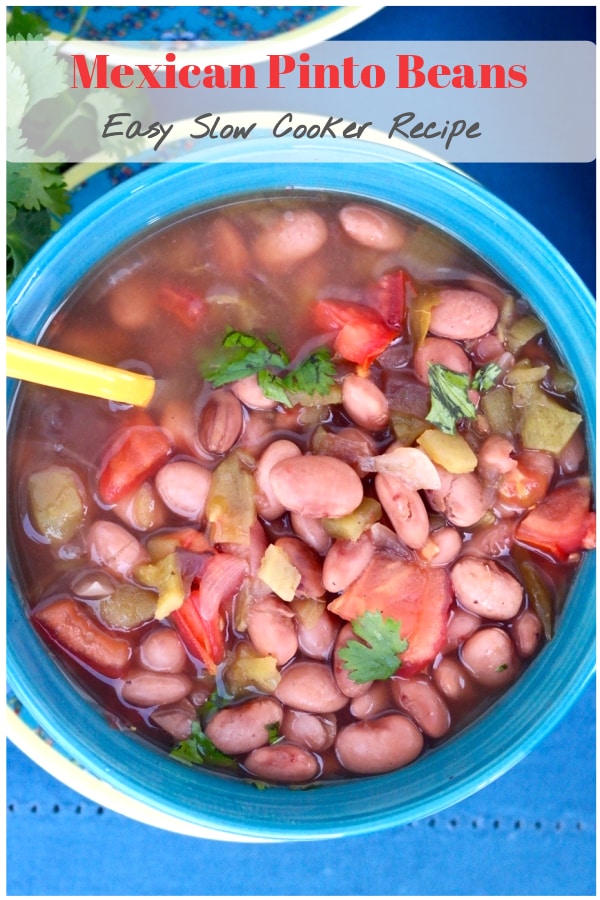 Tasty Mexican pinto beans made in a crock pot with flavorful spices like cumin, oregano, and fresh chopped tomatoes. Serve this as a main dish or a side to your favorite Latin meal!  #slowcooker #crockpot #beans #Mexican 