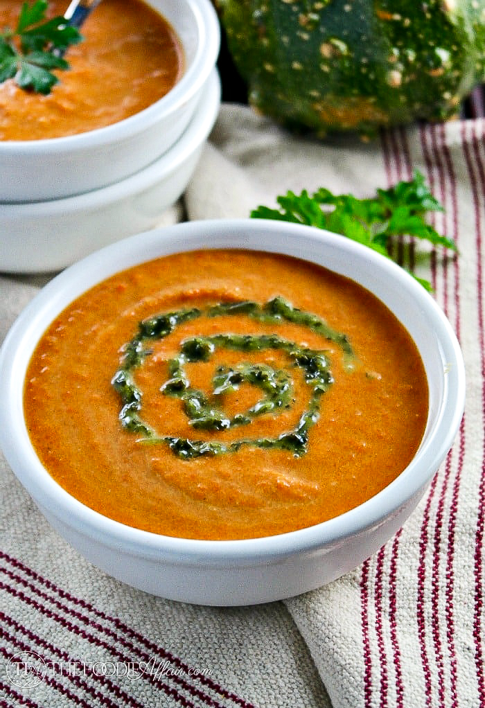 Carrot curry soup with coconut milk in a white bowl. 