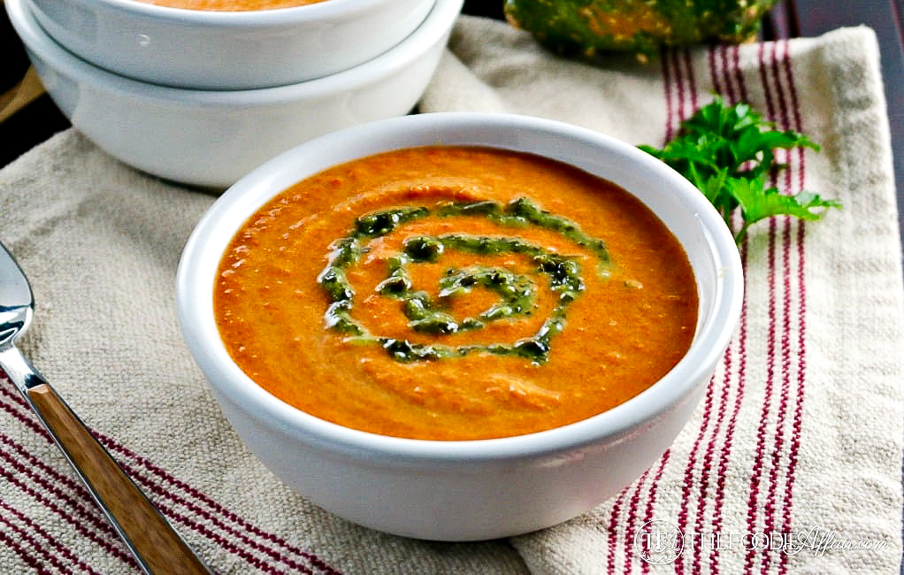 vegan carrot curry soup topped with a swirl of cilantro puree.