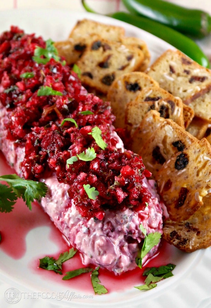 Cranberry jalapeno salsa with crackers on a white serving plate