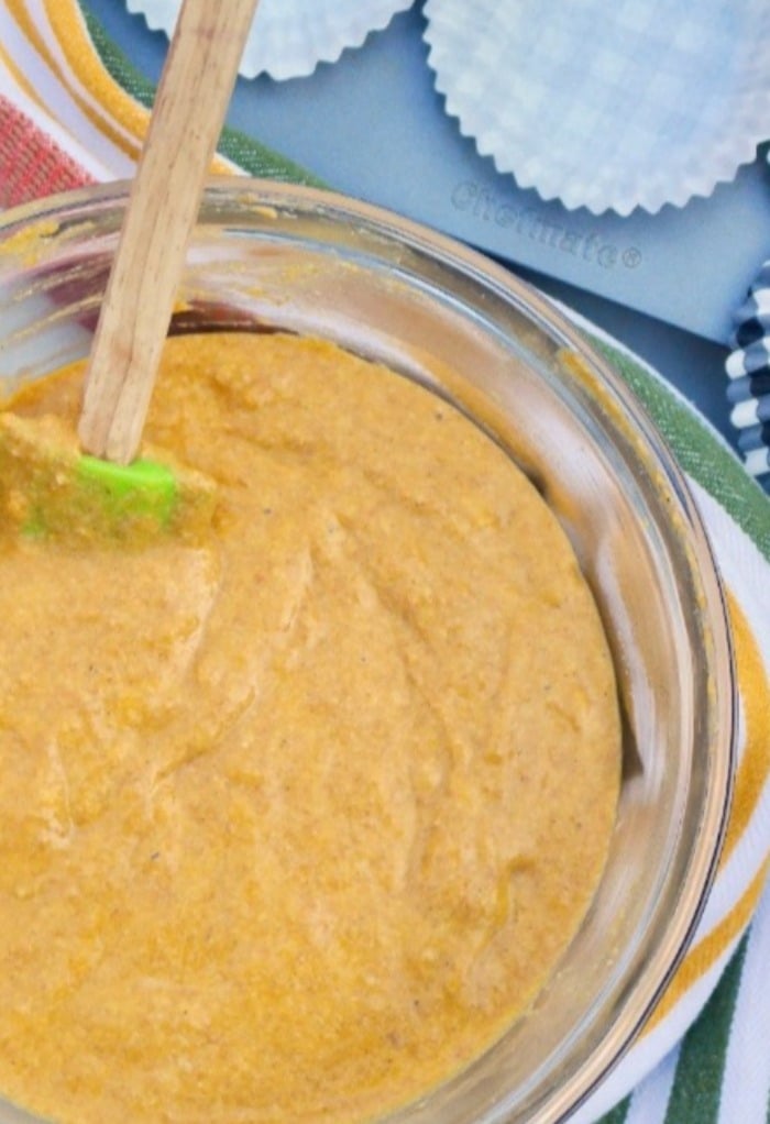 Sweet potato muffin batter in a large clear mixing bowl. 