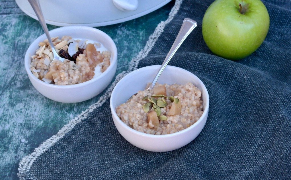 Two bowls filled with oatmeal in white bowls ready to be eaten.