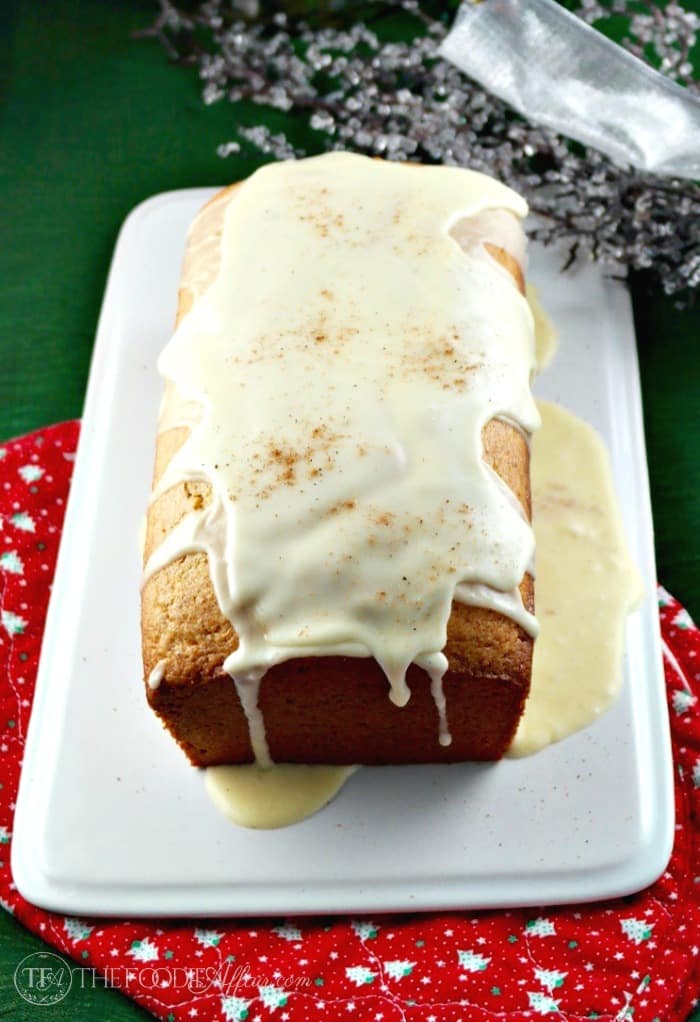 A loaf of eggnog bread on a white serving plate 