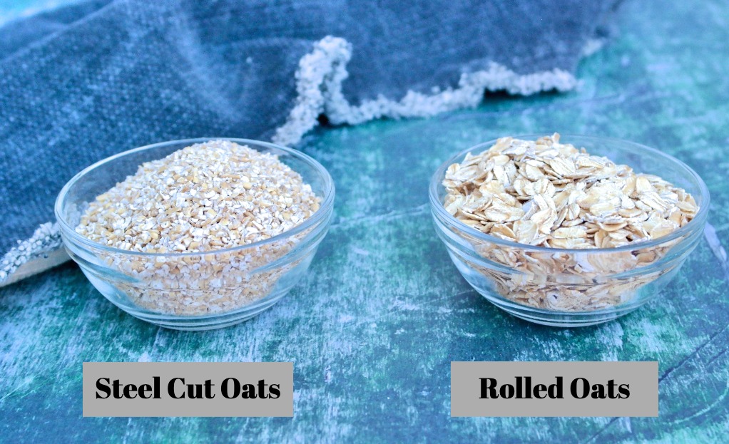 Two types of uncooked oatmeal, rolled and steel oats in a small glass bowl.