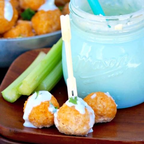 Bitesize buffalo chicken meatballs with blue cheese dressing on a wooden plate