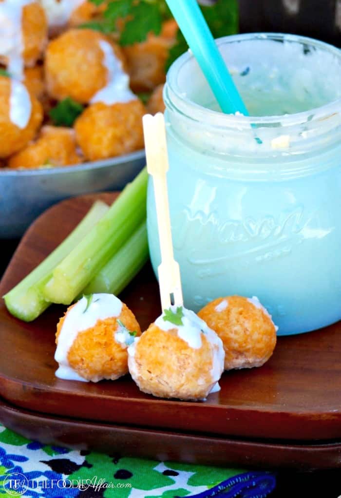 Bitesize buffalo chicken meatballs with blue cheese dressing on a wooden plate