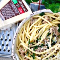 Bucatini pasta with Sausage and Kale in a serving dish.