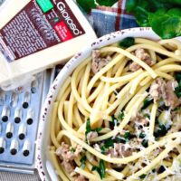 Bucatini pasta with Sausage and Kale in a serving dish.