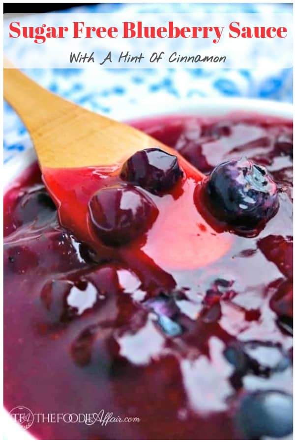 Homemade blueberry sauce in a white bowl with a wooden spoon 