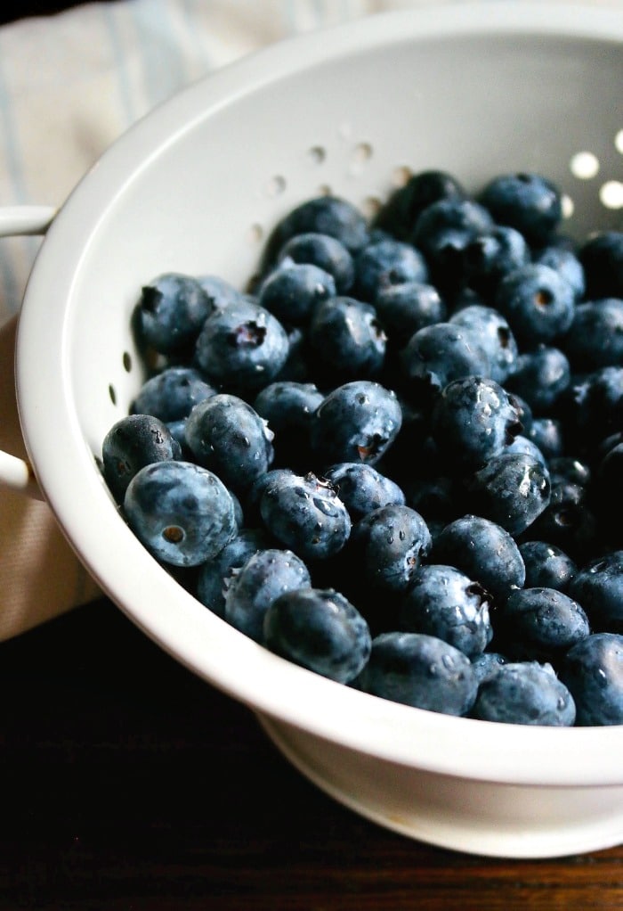 fresh blueberries in a white colander 