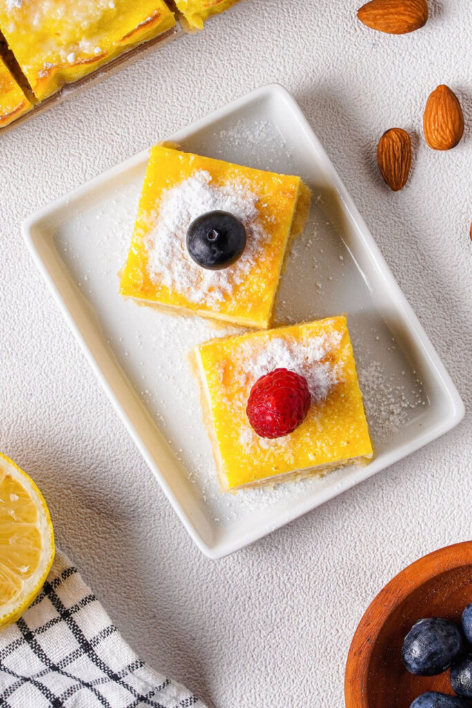 Top view of lemon bars on a white square plate.