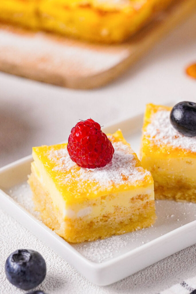 Lemon bars with a raspberry on top.