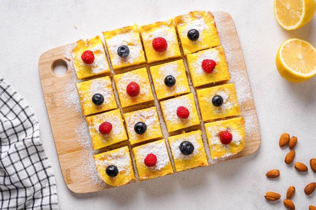 Lemon bars topped with confectioners sugar and fresh berries.