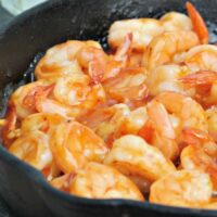 A cast iron skillet filled with tequila shrimp ready to be served