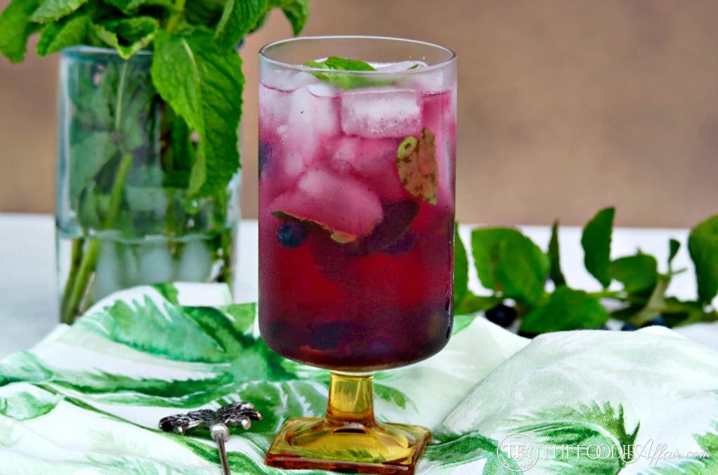 Homemade blueberry mojito cocktail on a green napkin