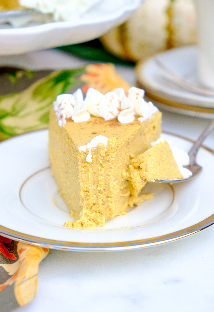 A slice of keto pumpkin cheesecake with a forkful of cake ready to eat. 