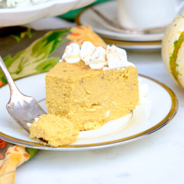 Slice of pumpkin cheesecake on a white plate.