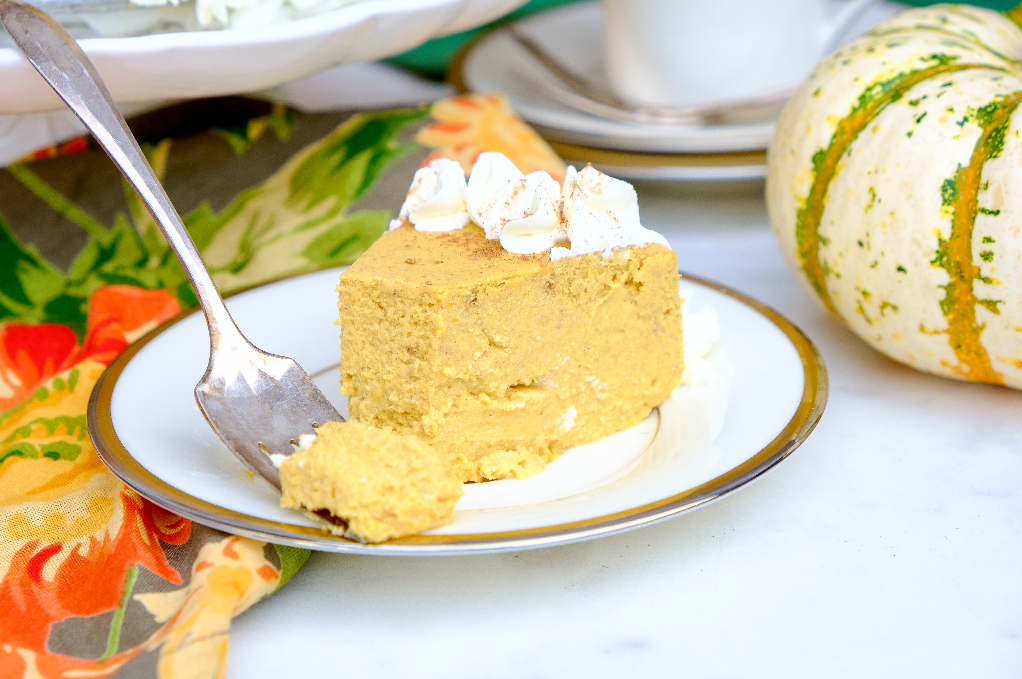 Slice of pumpkin cheesecake on a white plate.