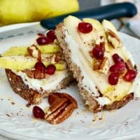 Ricotta toast with pears and pecans on a white plate