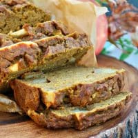 Loaf of pumpkin apple bread sliced on a cutting board