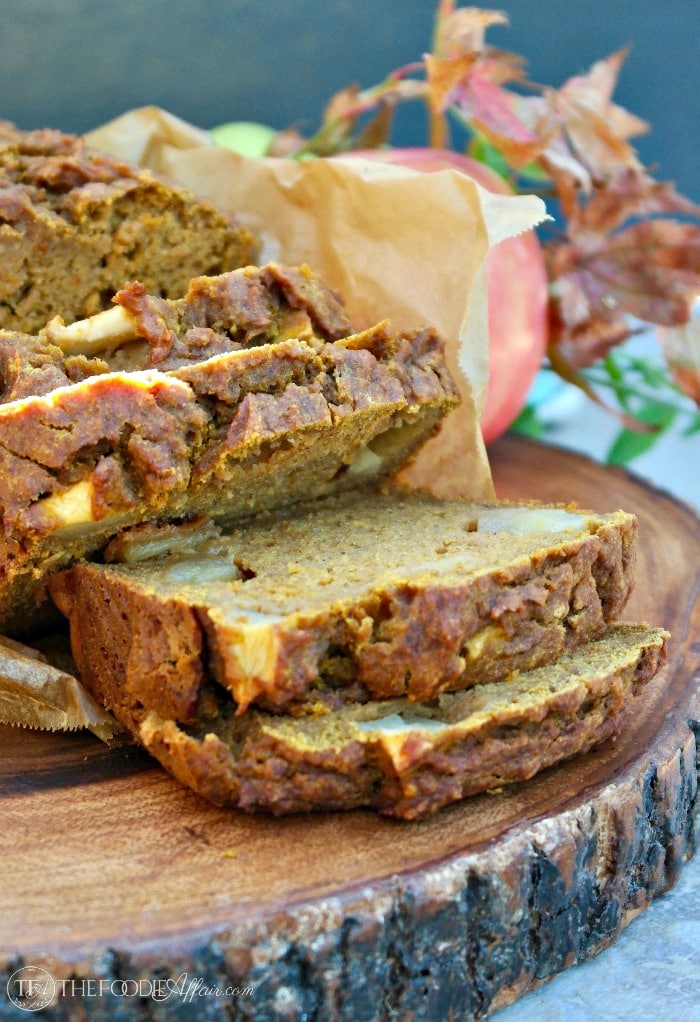 Loaf of pumpkin apple bread sliced on a cutting board