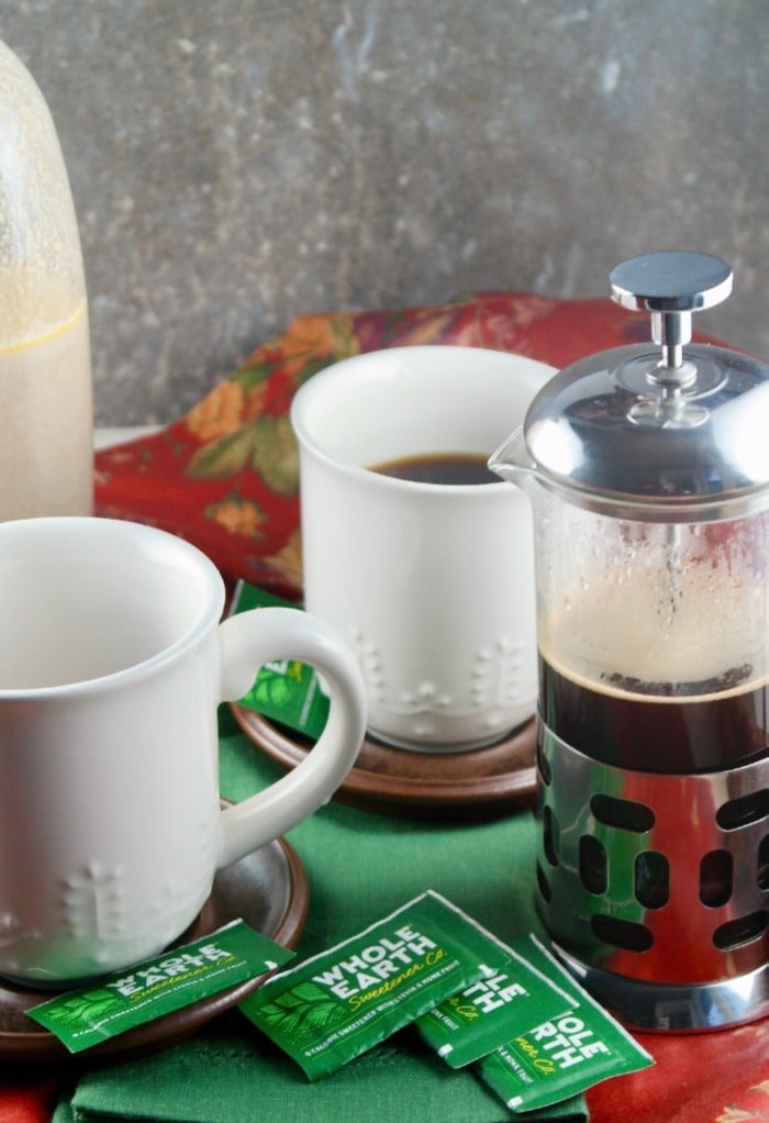 Fresh coffee made in a French press with white coffee cups on the side. 